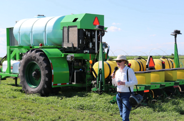 A woman next to a tractor.