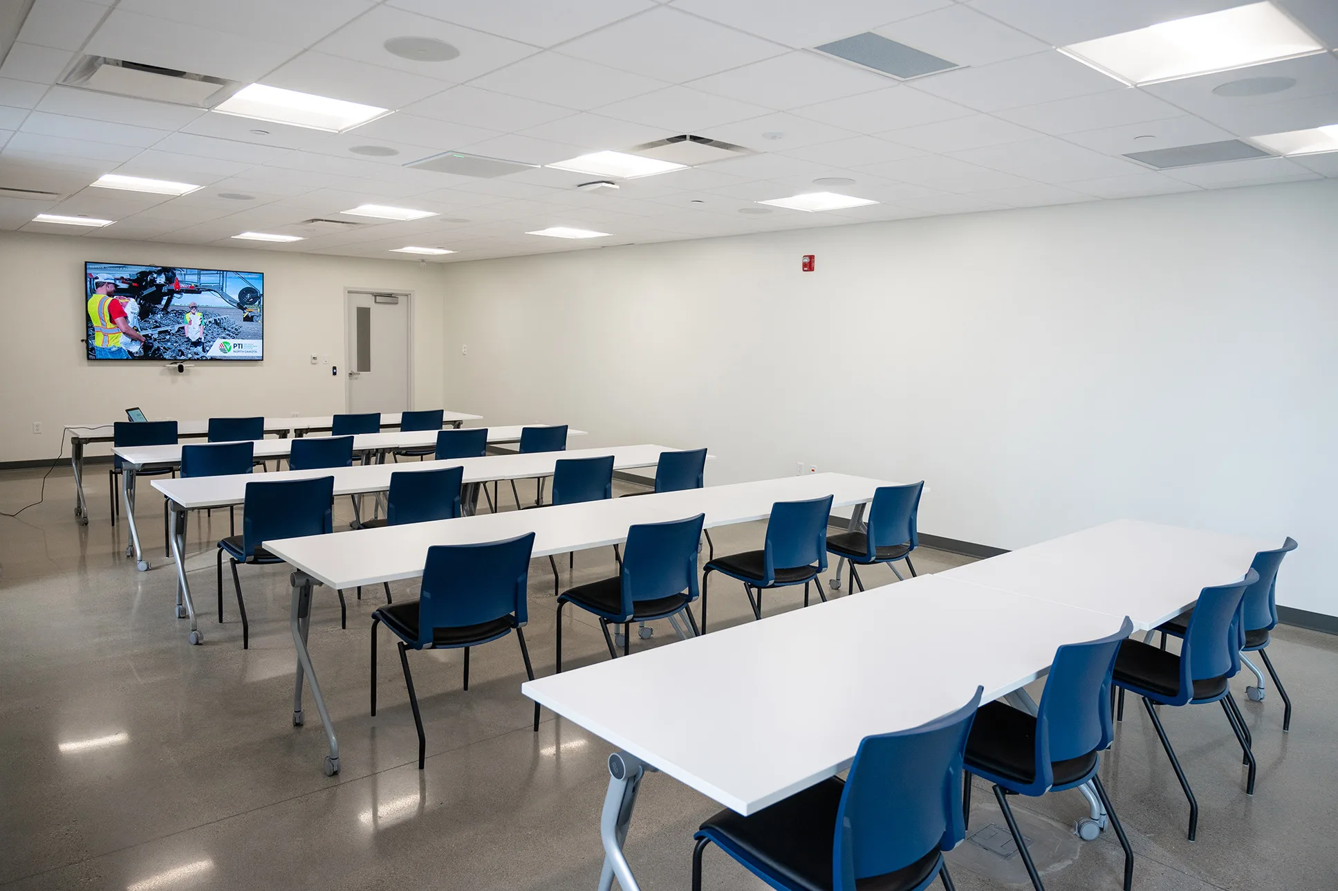 View of the Grand Farm Innovation Shop Classroom - back of room featuring tables and chairs